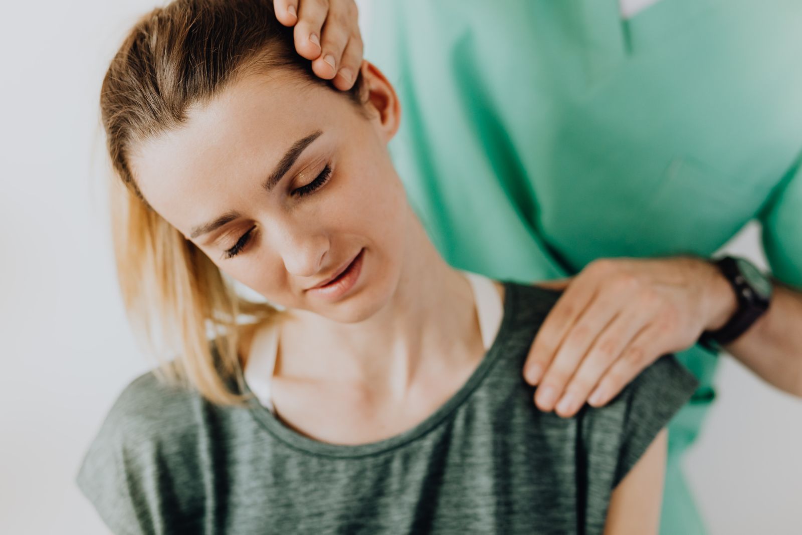 Physiotherapist gently mobilizing a patient's neck during a cervical spine treatment session