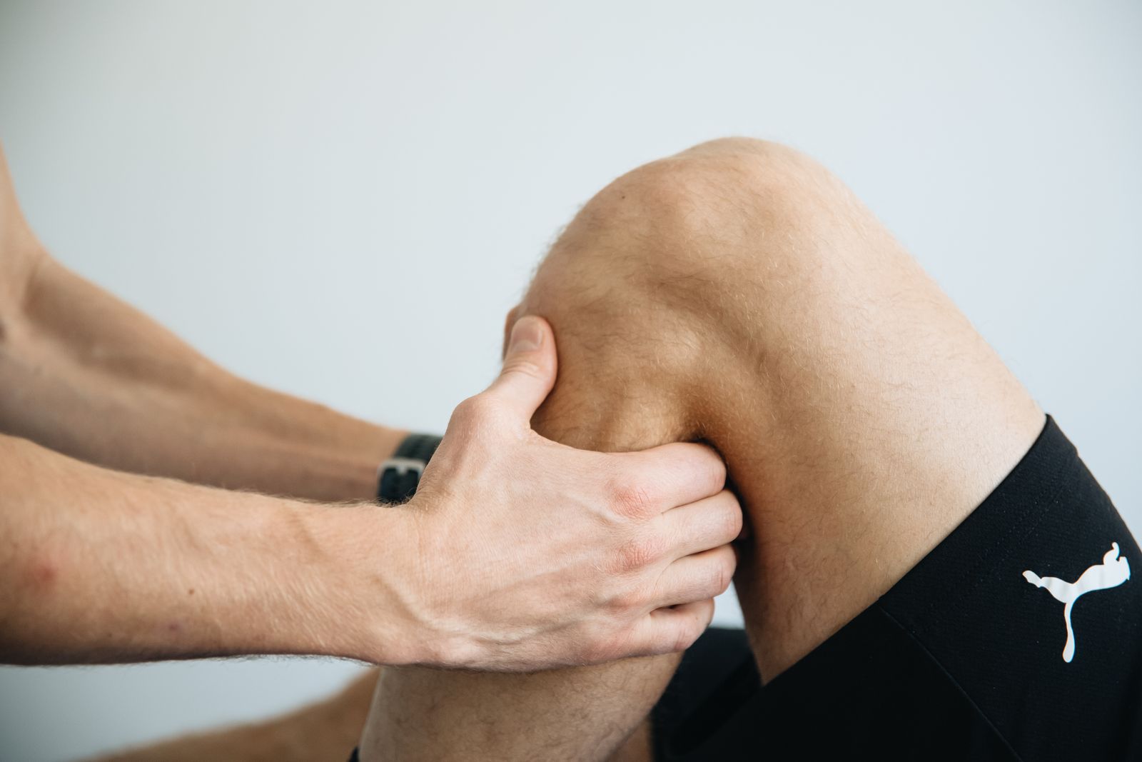 Physiotherapist massaging a patient's knee during sports injury rehabilitation